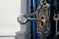 Una llave metálica recién forjada entrando en la cerradura de un portón ornamentado, con una segunda llave prestada colgando sin uso a un costado