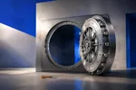 Una bóveda de acero con la puerta abierta de par en par y el mecanismo de cierre intacto, y una llave dorada olvidada en el piso a un costado
