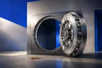 Una bóveda de acero con la puerta abierta de par en par y el mecanismo de cierre intacto, y una llave dorada olvidada en el piso a un costado