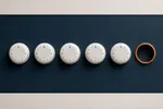 Cinco diales blancos alineados en fila sobre un panel azul cobalto, y un sexto zócalo vacío con un aro ámbar al final de la fila