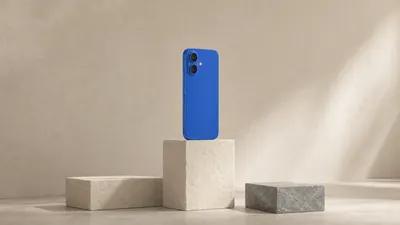 Un teléfono azul cobalto de pie sobre el bloque más alto de un podio de piedra clara de tres escalones, con los dos bloques laterales vacíos.