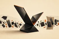 Una silueta plegable abstracta se abre con confianza sobre un fondo de fragmentos dispersos color ámbar, metáfora de Apple apostando fuerte por su producto más caro en medio de la escasez de componentes.