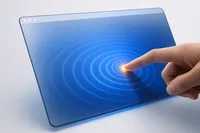 Un dedo toca una pantalla de cristal y genera ondas cobalto, con un destello ámbar en el punto de contacto